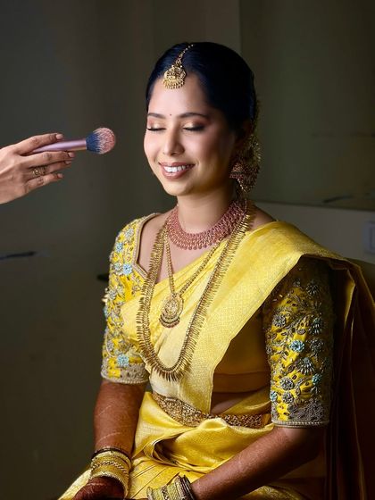 The process of creating a soft glow. Here, I am applying a gentle blush to my South Indian bride, ensuring her skin looks naturally flushed and healthy in her yellow saree.