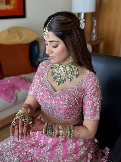 A serene moment captured before the ceremony. The soft pink makeup creates a dreamy and romantic feel.