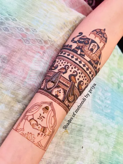 The design continues down the arm with a depiction of a bride during a wedding ritual. Each band of the mehendi tells a different part of the story.