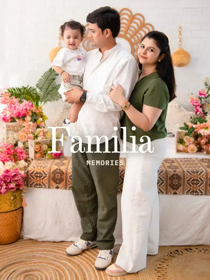 A standing family portrait that exudes warmth. The coordinated green and white outfits pop against the floral and rattan decor, creating a fresh and modern family photo.