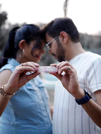 The moment it all began. This photo captures the couple's joy as they look at a positive pregnancy test together, a perfect start to their maternity photo story.