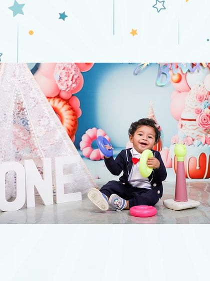 A playful moment from a first birthday shoot. This little boy enjoys playing with stacking rings, showing that even the simplest moments are worth capturing.
