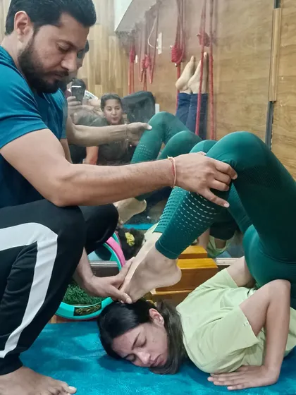 In our teacher training, hands-on adjustment is a key skill. Here, I am guiding a trainee on how to safely assist a student in a complex back-bending posture.