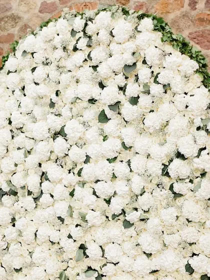 This luxurious white floral wall, created for an intimate Roka, provides a stunning and elegant texture. I provide services in both Mumbai and Dubai.
