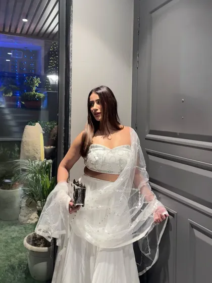 A classic white lehenga with a sequined blouse and net dupatta, perfect for a sophisticated Diwali party or festive celebration.