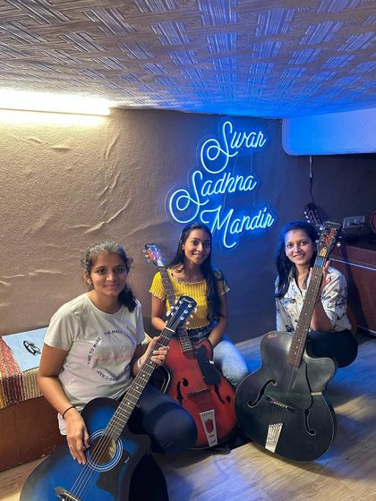 Three of our guitar students posing with their instruments in our studio. We are proud of our growing community of talented and passionate guitarists.
