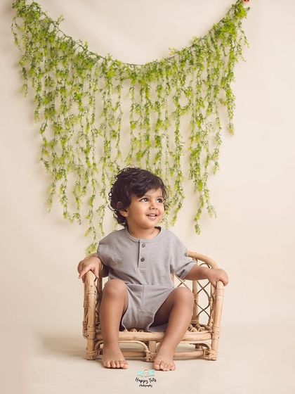 A full shot of this little one seated in a cute rattan chair. Simple props and backdrops are perfect for timeless kids' portraits.
