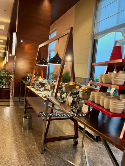 This shot captures the clean lines and modern aesthetic of the indoor catering setup. The A-frame wooden stands and minimalist lighting create a contemporary feel that is both functional and stylish.