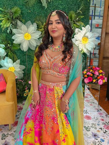 A full-length view of the stunning sangeet outfit. The makeup is designed to be vibrant yet elegant, matching the festive mood.