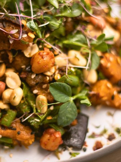 A macro shot of our Asian Peanut Salad, showing the delicious textures of roasted chickpeas, peanuts, and fresh microgreens. We recommend adding tofu for an extra protein kick.