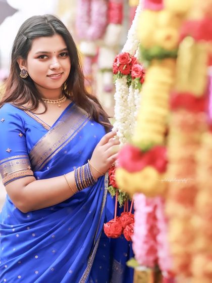 Portraits of a model in a vibrant blue saree, shot within the historic and atmospheric corridors of a temple. The stone pillars and natural light create a dramatic and timeless setting.