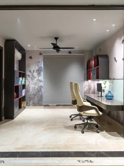 A wide view of the home office, showing the long desk and ergonomic chairs. The space is separated by a sliding glass partition, allowing for both privacy and an open feel.
