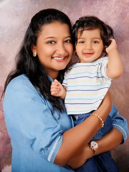 A classic mother and child portrait. The soft floral background adds a gentle, artistic touch to this sweet moment.