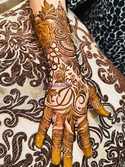 This full-hand bridal design features the initial 'A' surrounded by hearts and intricate floral patterns. It's a beautiful way to express your love.