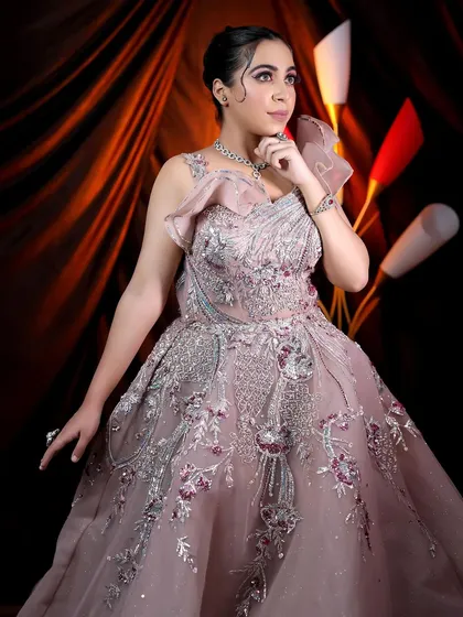 A portrait of the model, showcasing the intricate details of the gown and the sophisticated makeup look.