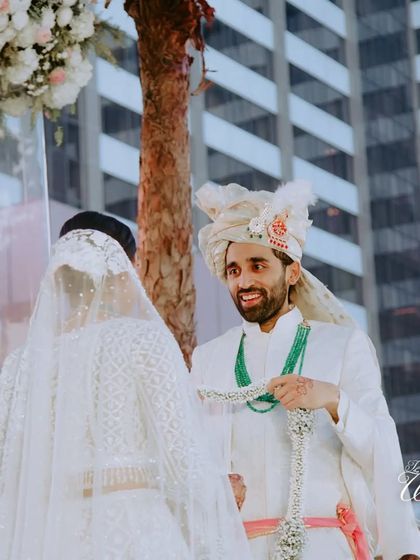 The groom's happy expression as he's about to place the Varmala. This moment of anticipation and joy is a highlight of the wedding ceremony.