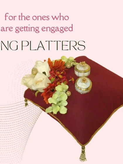 This classic ring platter features a plush maroon cushion, providing a rich and royal backdrop for your wedding rings. The small, ornate boxes are perfect for holding the rings securely until the big moment.