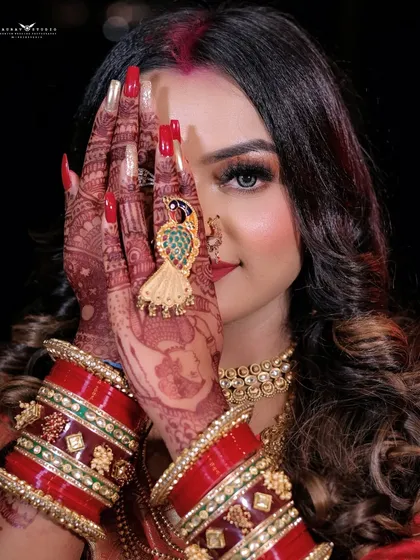 A creative shot with the model's face partially hidden by her henna-adorned hands.