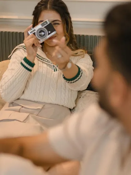 Turning the camera back on us. This fun, interactive moment shows the playful dynamic of the couple during their relaxed indoor pre-wedding session.