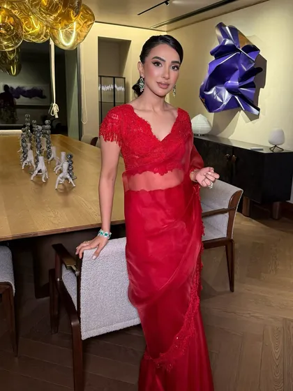 A full view of Nayana's iconic red saree look. The makeup is bold yet elegant, perfect for making a statement at a reception or cocktail party.