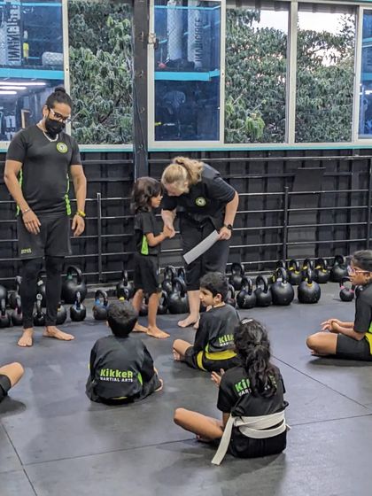 A coach congratulates Lucah on becoming Kikker of the month in front of his classmates. We celebrate every achievement.