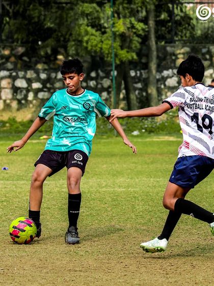 A player maintains control of the ball while being closely marked by a defender, a test of skill and composure.
