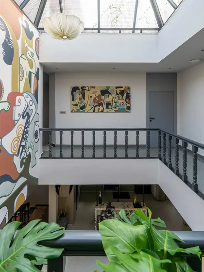 A view from the balcony, showcasing the scale of the double-height mural and its integration with the home's interior design.