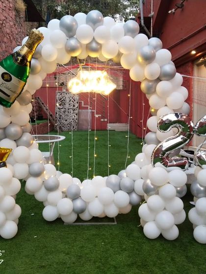 A clear shot of the 23rd birthday decor, highlighting the champagne bottle balloon and foil number balloons that personalize the celebration.