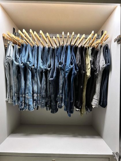 Hanging jeans on sturdy wooden hangers not only saves drawer space but also makes it easy to see your entire collection and pick a pair without unfolding everything.