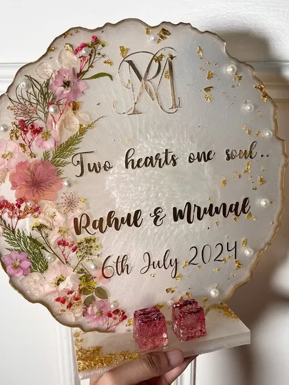 A standing ring platter with a delicate pink floral design. The couple's monogram and the quote 'Two hearts one soul' are beautifully displayed.