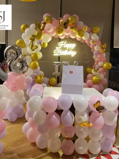 A whimsical Unicorn-themed 8th birthday with a pastel balloon arch, unicorn and butterfly foil balloons, and a neon sign.