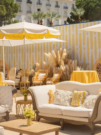 The lounge area was designed for comfort and style, with elegant white sofas, macrame cushions, and pops of yellow, creating a perfect space for guests to relax.