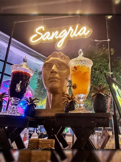 I offer specialized drink stations to cater to all tastes. This is my dedicated Sangria station, featuring beautiful glass dispensers with both red and white wine options, garnished with fresh fruit for a refreshing treat.