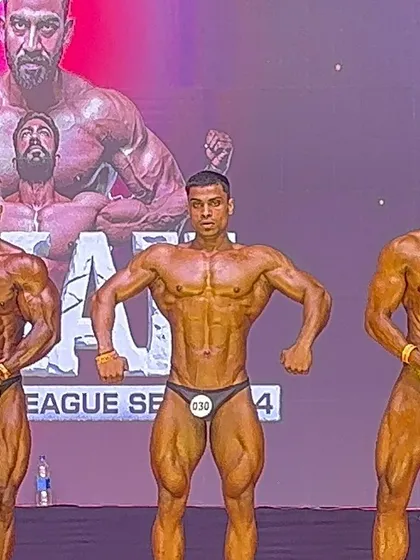 This is a front lat spread pose comparison on stage. Notice the V-taper and the detailed back musculature. We focus heavily on developing symmetry and mastering these mandatory poses to score high with the judges.