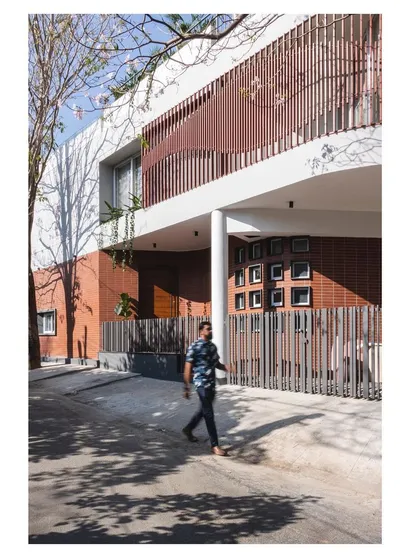 The 'House Under Tabebuia Trees' features a 15-meter panoramic and parametric facade. This curved form, a significant structural challenge, was designed to wrap around the view, creating a dynamic interplay of light and shadow that changes throughout the day. It is a testament to our fascination with bold, cantilevered structures.