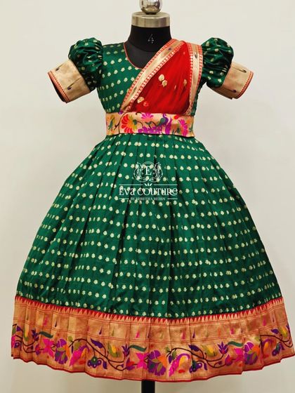A one-piece frock in green, designed to look like a half-saree with an attached red and floral Paithani-style drape.