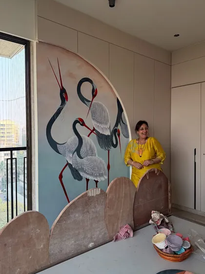 My mother, the artist, stands proudly next to the hand-painted crane mural she created for this bedroom. This image captures the personal and collaborative spirit that I bring to my projects.