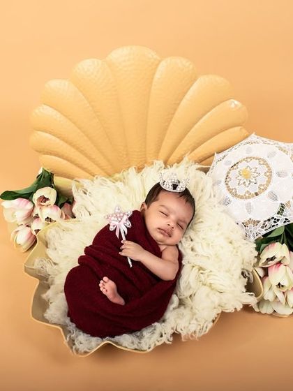 A creative newborn setup featuring a seashell prop. This 'pearl in a shell' theme is a unique and beautiful way to photograph your precious newborn.