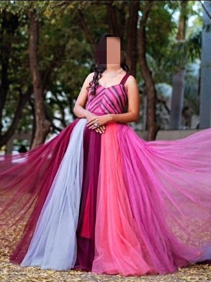 This multi-colored flying gown is a vibrant and joyful choice for any photoshoot. The mix of pink, maroon, and grey tulle creates a beautiful effect when the fabric flows.