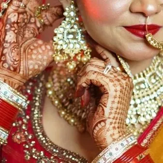 A detailed shot of the bride's hands, showcasing her mehndi, ring, and earrings. These close-ups highlight the beautiful bridal accessories.