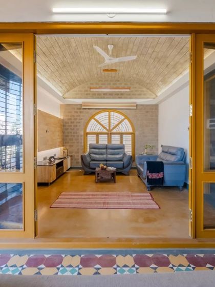 A view from the semi-open lounge into the family room, showcasing the vaulted brick ceiling and the seamless connection between spaces.