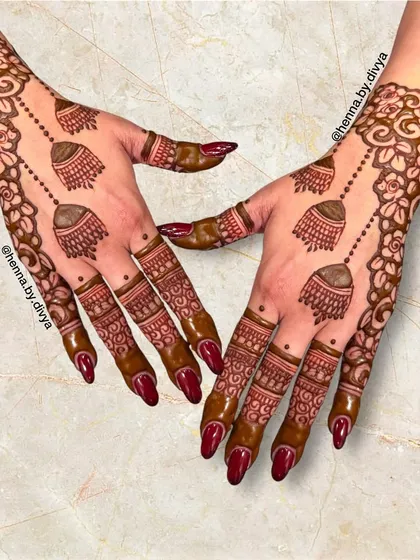 A bold and beautiful design featuring large, detailed jhumkas as the central element. The floral vine border completes this classic and celebratory party mehendi look.