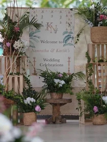 Your story begins the moment your guests arrive. We design personalized welcome signage and entryways, like this rustic-chic setup with wooden crates, fresh greenery, and a custom welcome board, to create a warm and inviting first impression.