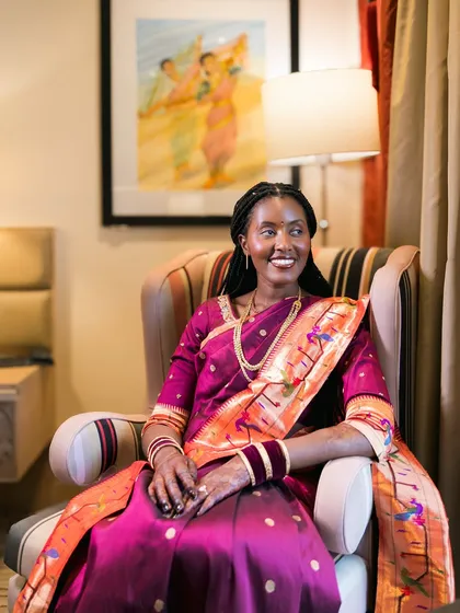 A happy, relaxed portrait of a bride in a beautiful magenta and orange saree.