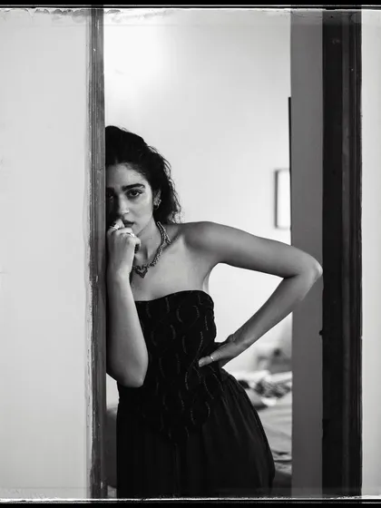 A black and white portrait of Kavya Trehan peeking from behind a doorway. It’s a simple composition that feels intimate and a little mysterious.