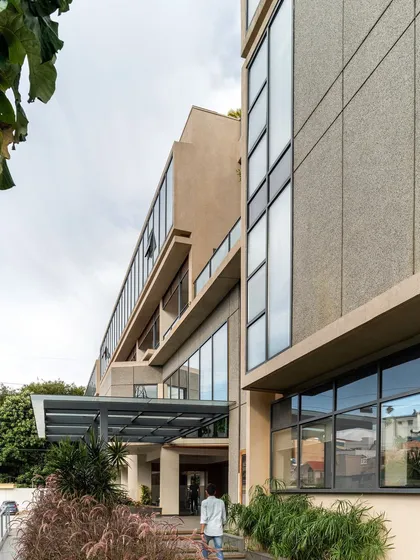 The entrance pathway to the Koramangala Club annexe. The design uses landscaping and a transparent canopy to create a welcoming approach that blurs the line between the building and its natural surroundings.