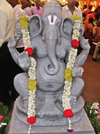 Every event begins with a prayer. A beautiful Ganesha idol adorned with garlands at the entrance of a marriage ceremony, seeking blessings for the event.