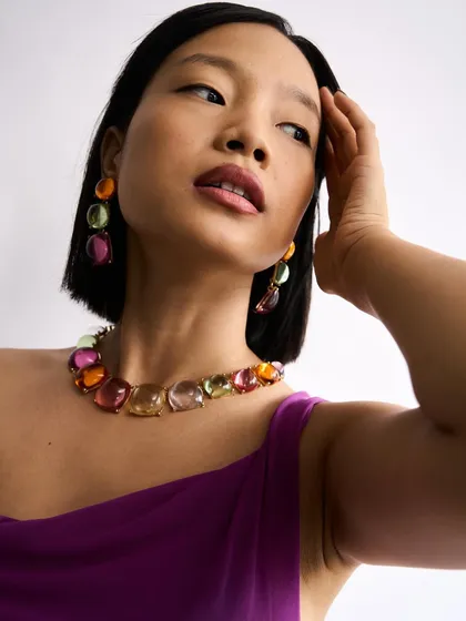 A clean and modern look for a test shoot, featuring a short bob and makeup that complements the colorful jewelry without competing with it.