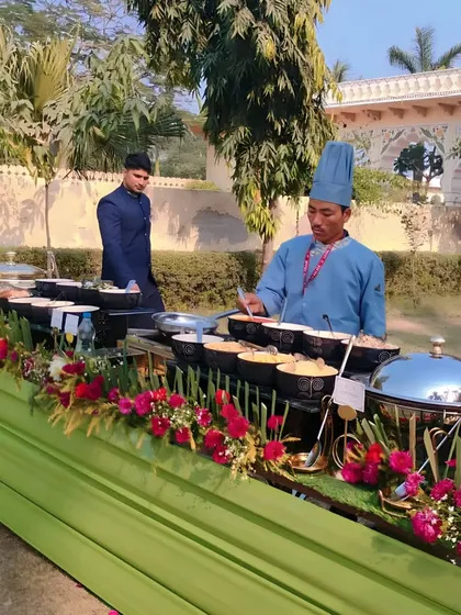 Another angle of the outdoor buffet, highlighting the fresh and colorful floral arrangements that run along the entire length of the table.