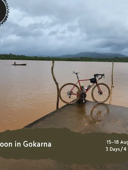 This image announces our 4-day 'Monsoon in Gokarna' tour, capturing the unique beauty of the region with a bike overlooking the backwaters as a fishing boat passes by.